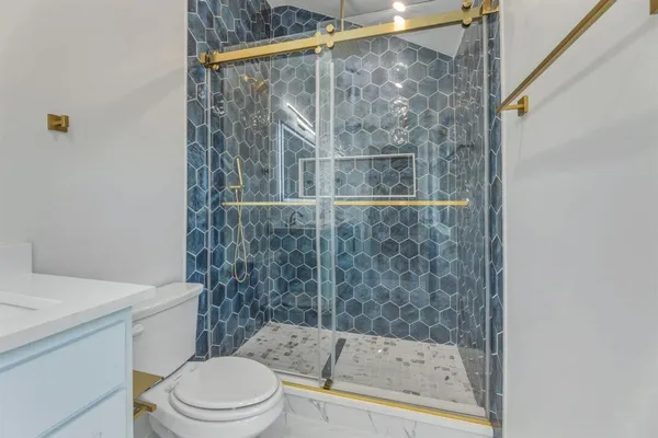 a bathroom with a shower a toilet and a sink