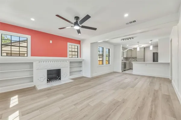 a view of a livingroom with a fireplace window and wooden floor
