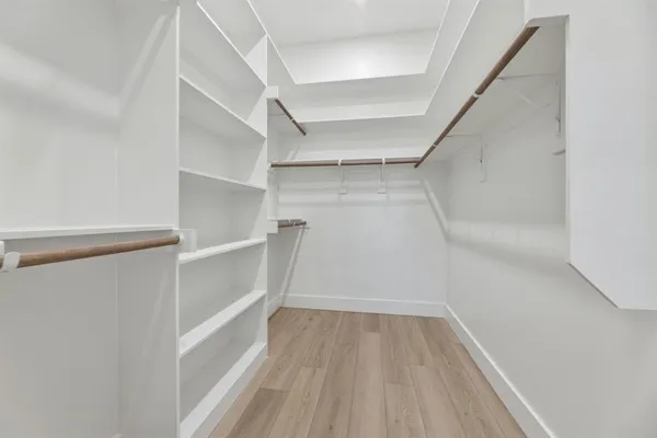 a view of walk in closet with empty racks
