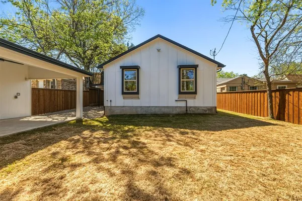 a view of a house with backyard and tree