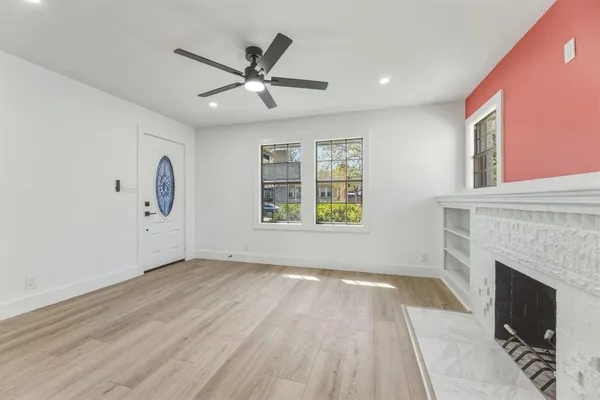 a view of a livingroom with a fireplace window and wooden floor