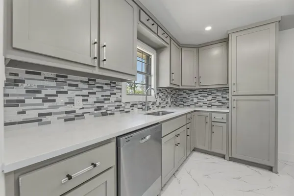 a kitchen with white cabinets and white appliances