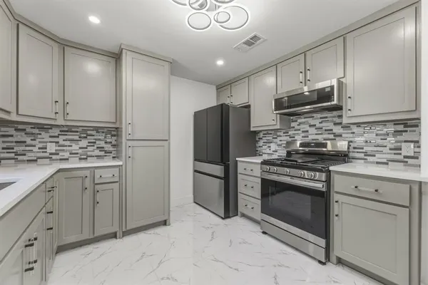 a kitchen with stainless steel appliances granite countertop a refrigerator stove and sink