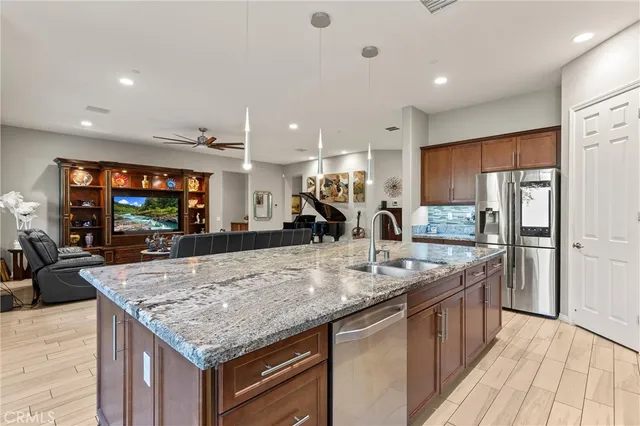 a kitchen with stainless steel appliances granite countertop counter top space a refrigerator and cabinets
