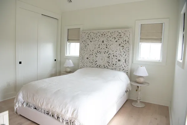 a large bed sitting in a bedroom next to a window