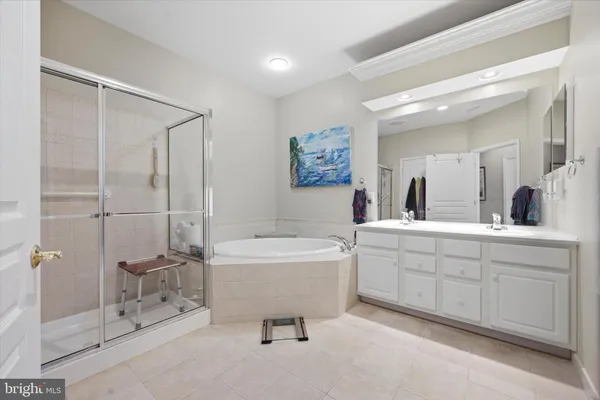 a spacious bathroom with a double vanity sink a mirror and a bathtub