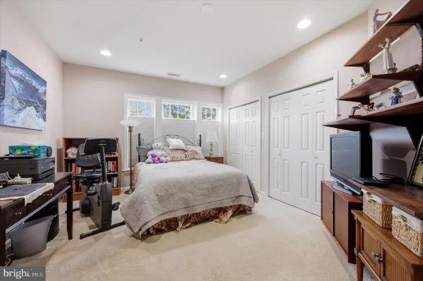 a bedroom with a bed and flat tv screen on the dresser