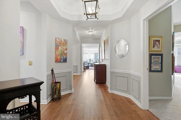 a view of a hallway with furniture and wooden floor