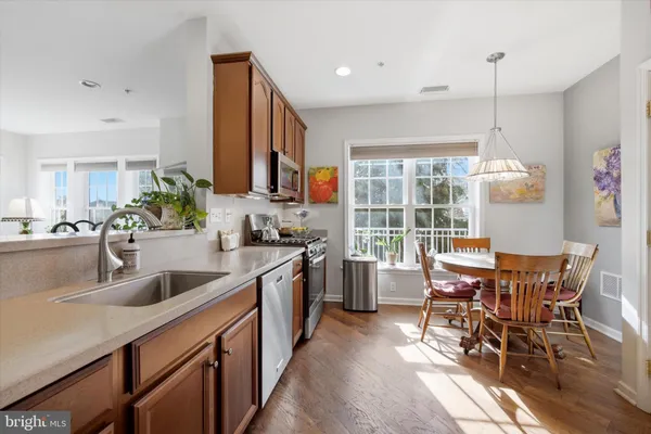 a kitchen with stainless steel appliances granite countertop table chairs sink and cabinets