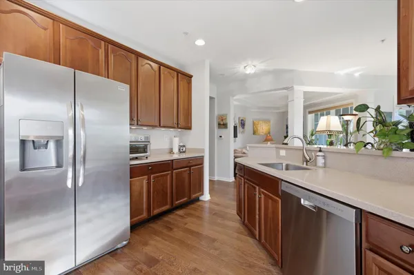 a kitchen with stainless steel appliances granite countertop a refrigerator a sink and a stove