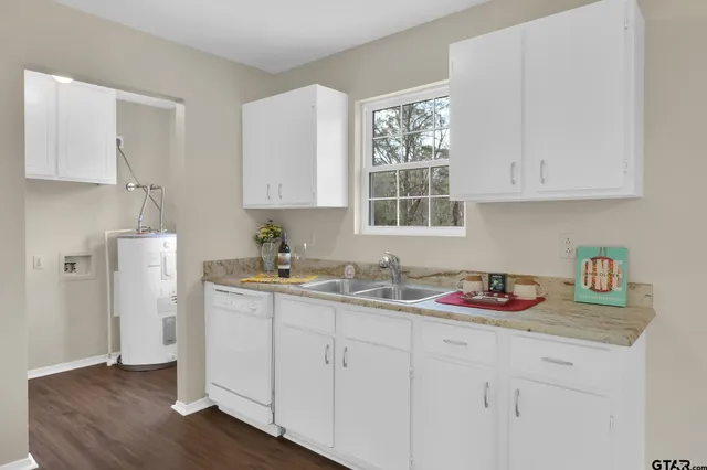 a kitchen with white cabinets and sink