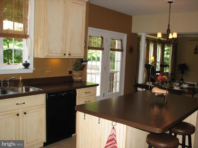 5910 Sunlight Mountain Road Spotsylvania, VA 22553 - Photo 19 of 30 a kitchen with granite countertop a sink a counter top space and living room filled with furniture