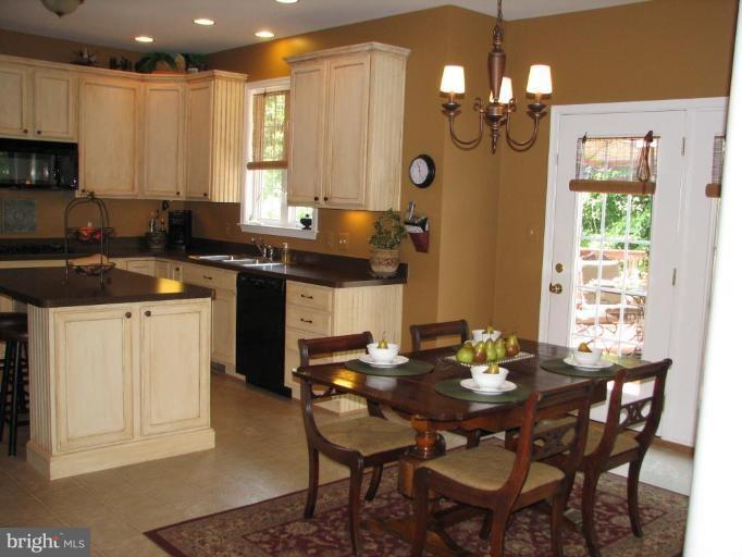 5910 Sunlight Mountain Road Spotsylvania, VA 22553 - Photo 27 of 30 a kitchen with a table chairs stove and microwave