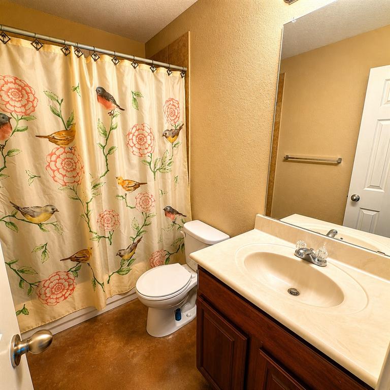 2003 Firefly Circle Waco, TX 76705 - Photo 21 of 29 Bathroom featuring a single vanity with wood-finish cabinetry, an integrated sink, and a large wall-mounted mirror