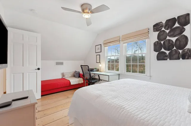 a bedroom with a bed next to a window and a chandelier