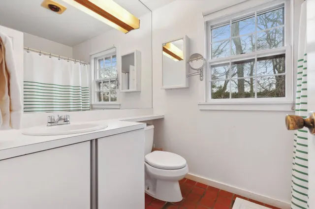 a bathroom with a sink a toilet and a window