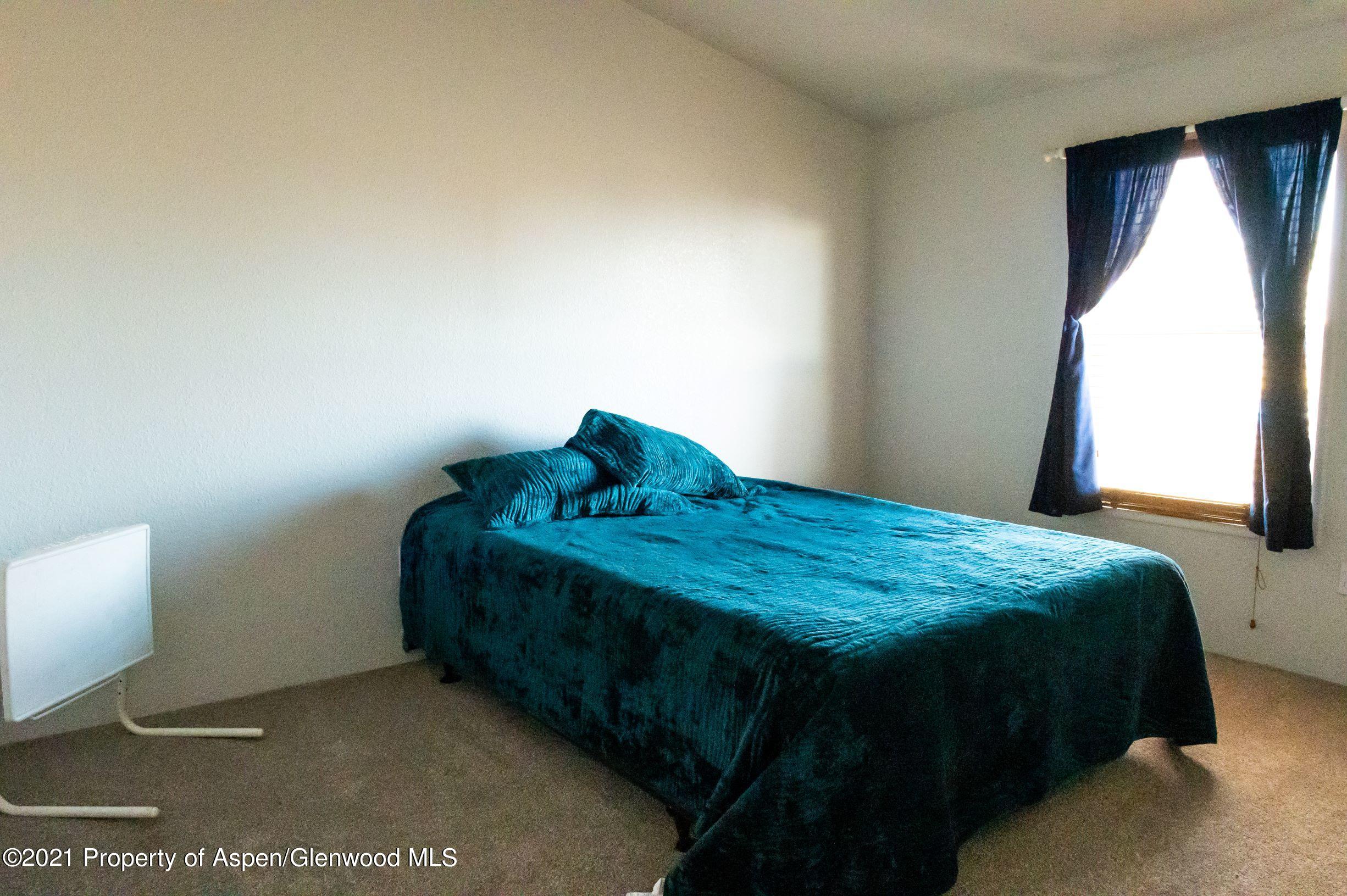 3171 County Road 233 Rifle, CO 81650 - Photo 15 of 36 a bedroom with a bed and window