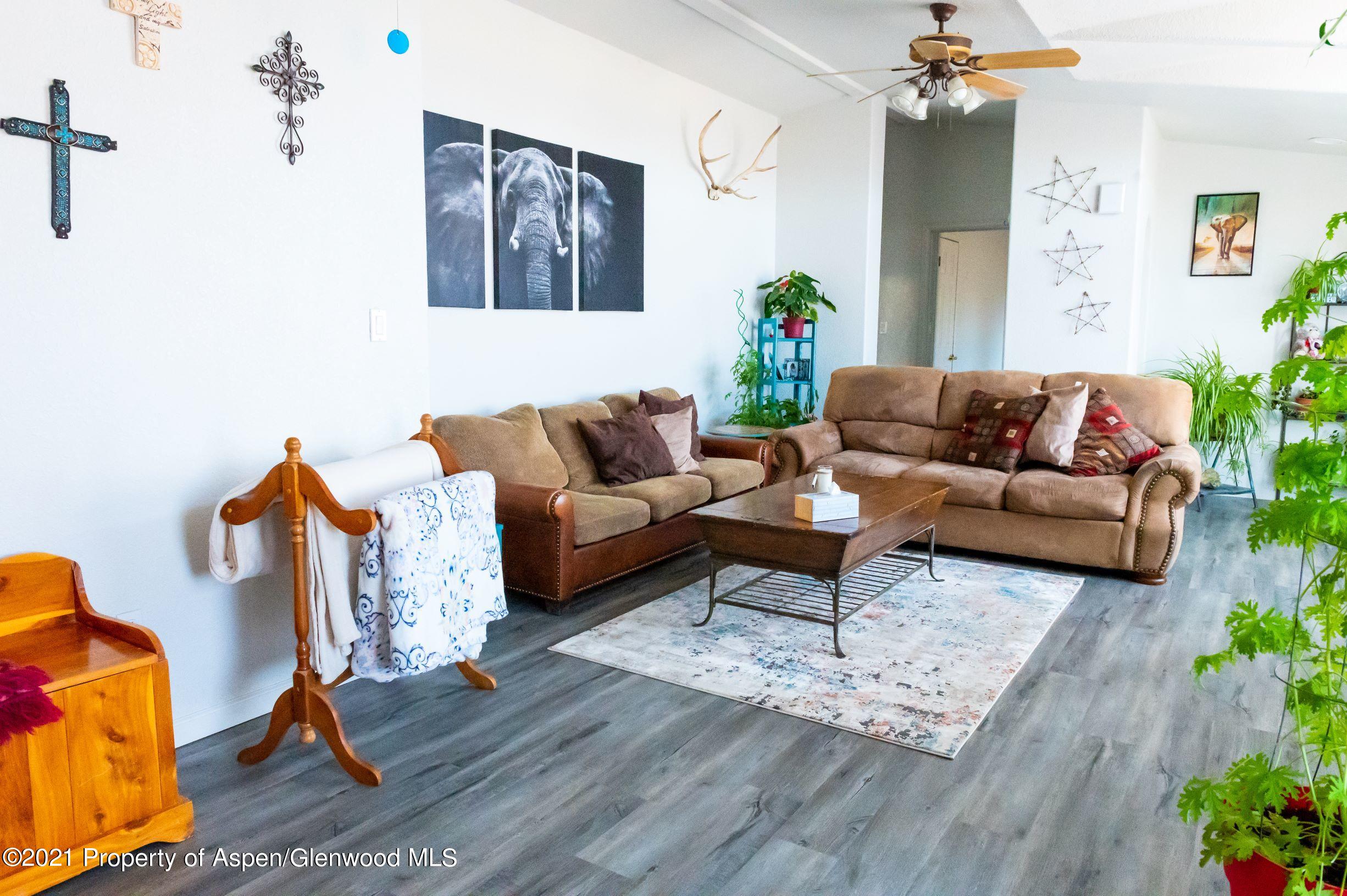 3171 County Road 233 Rifle, CO 81650 - Photo 9 of 36 a living room with furniture flowers and a wooden floor