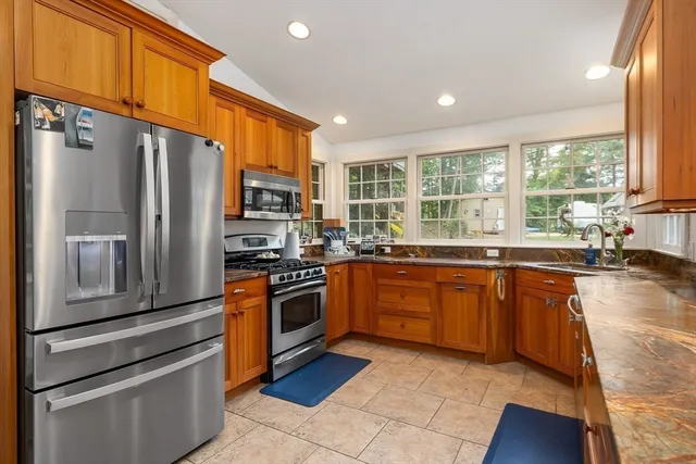 a kitchen with stainless steel appliances granite countertop a refrigerator a stove a sink and dishwasher