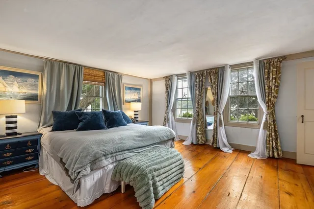 a bedroom with a bed and large windows