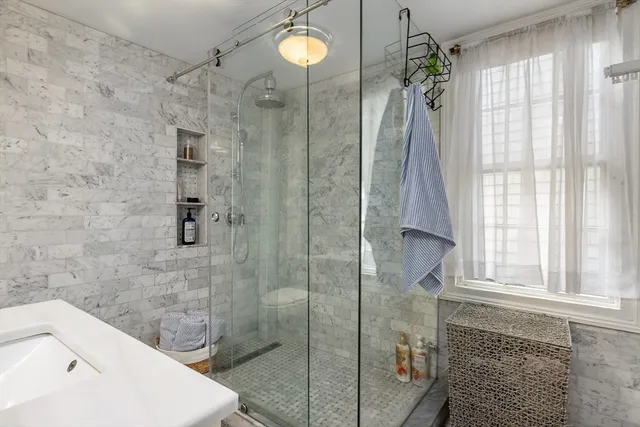 a bathroom with a sink a toilet and shower