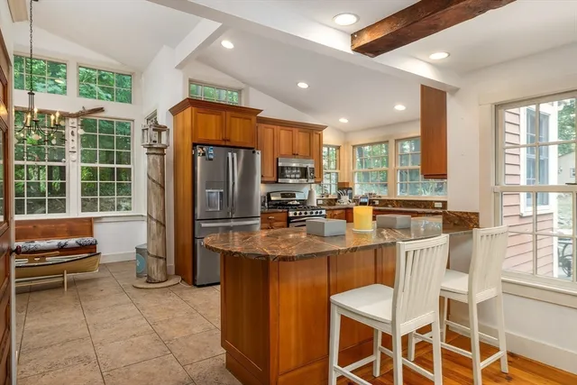 a kitchen with stainless steel appliances granite countertop a stove a refrigerator a sink and a dining table