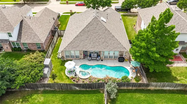 an aerial view of a house with swimming pool and garden