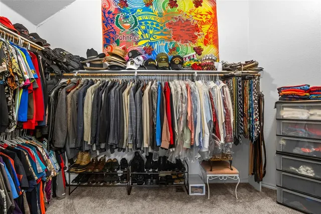 a view of walk in closet with clothes and shoes