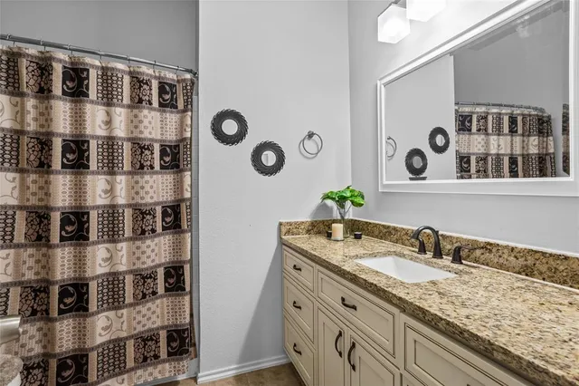 a bathroom with a granite countertop sink and a mirror