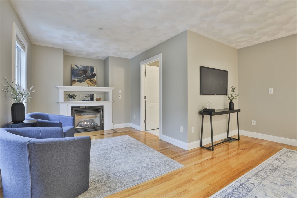 53 Cooper Street Wakefield, MA 01880 - Photo 20 of 42 a living room with furniture a fireplace and a flat screen tv