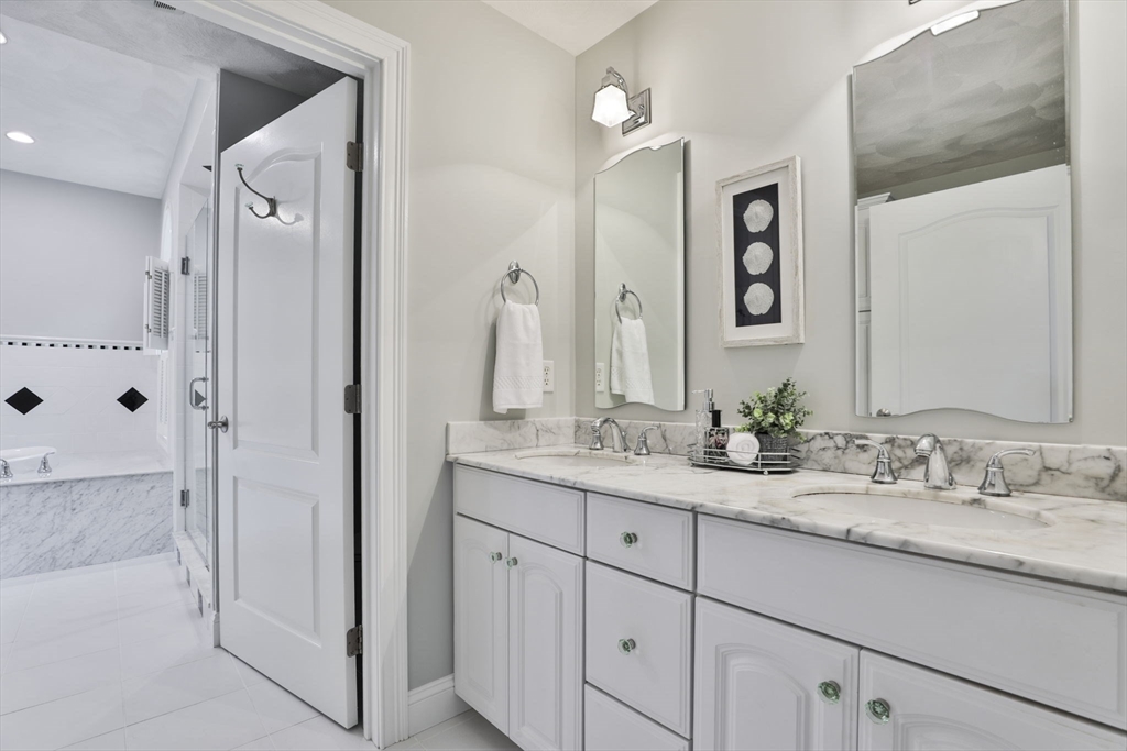 53 Cooper Street Wakefield, MA 01880 - Photo 21 of 42 a bathroom with a granite countertop sink vanity mirror and shower