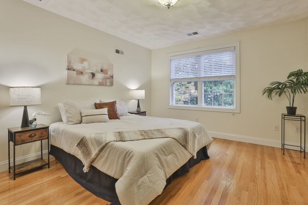 53 Cooper Street Wakefield, MA 01880 - Photo 27 of 42 a bedroom with a large bed and a potted plant