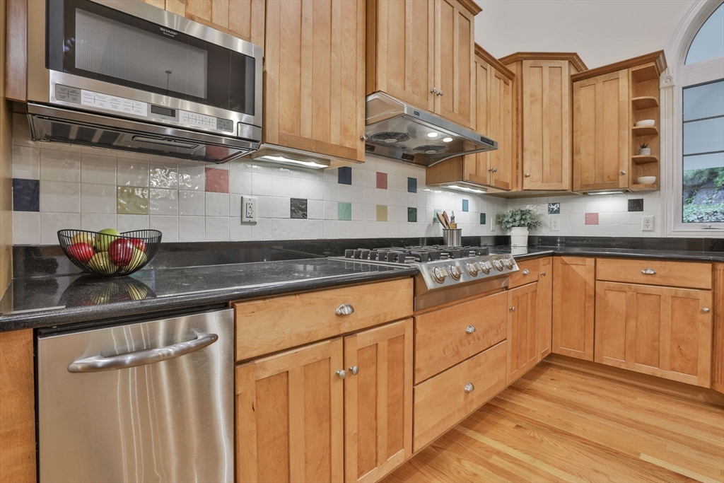 53 Cooper Street Wakefield, MA 01880 - Photo 6 of 42 a kitchen with stainless steel appliances granite countertop a sink a stove and a microwave