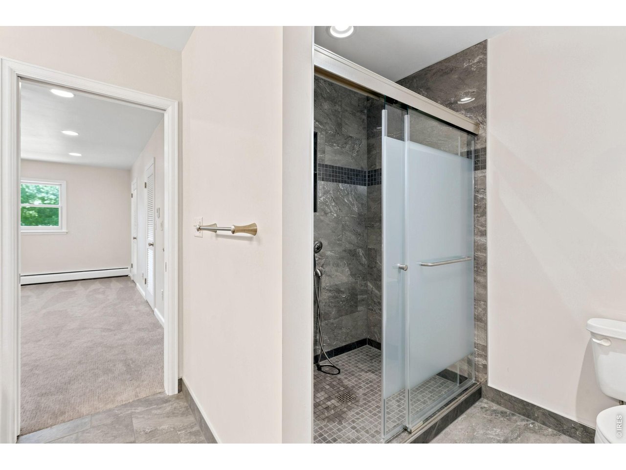 2121 18th Street Road Greeley, CO 80631 - Photo 28 of 40 New primary bath with tile surround and sliding glass doors.