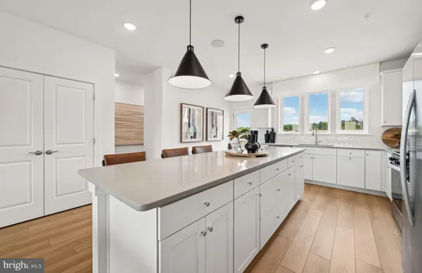 a kitchen with stainless steel appliances granite countertop a sink a stove and a wooden floors