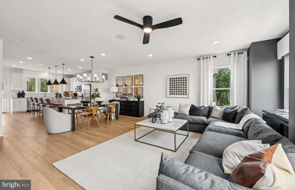 a living room with furniture kitchen view and a large window