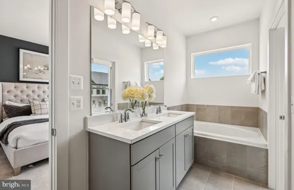 a bathroom with a bathtub sink and mirror