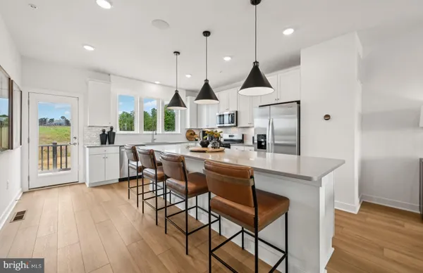 a kitchen with stainless steel appliances granite countertop wooden floor dining table and chairs