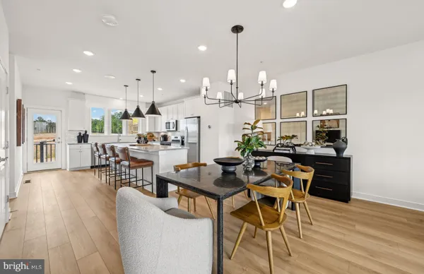 a view of a dining room and livingroom with furniture wooden floor a chandelier