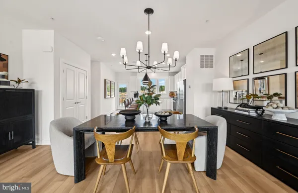 a view of a dining room with furniture a kitchen and chandelier