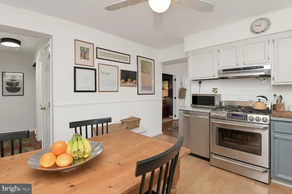 a kitchen with stainless steel appliances a stove a kitchen island a stove a table and chairs