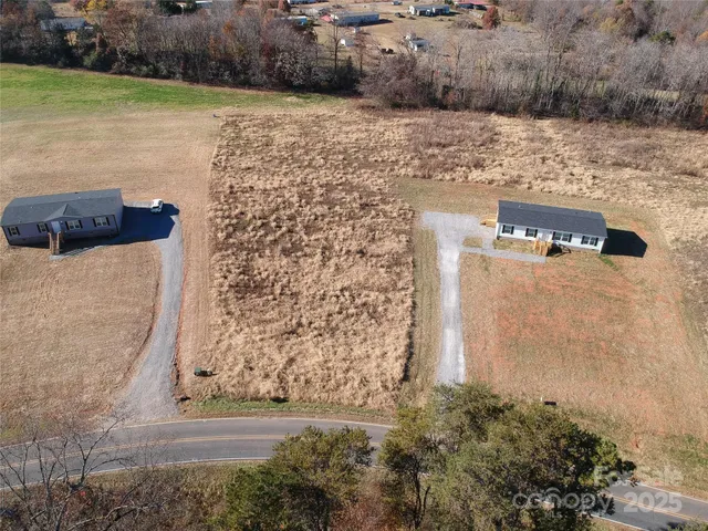 a view of swimming pool with lawn chairs and wooden fence