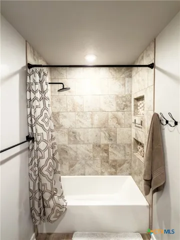 a bathroom with a bathtub and shower