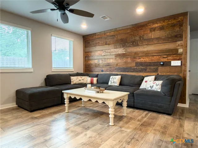 a living room with furniture and a ceiling fan