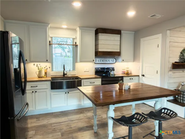 a kitchen with stainless steel appliances granite countertop a stove refrigerator sink and cabinets