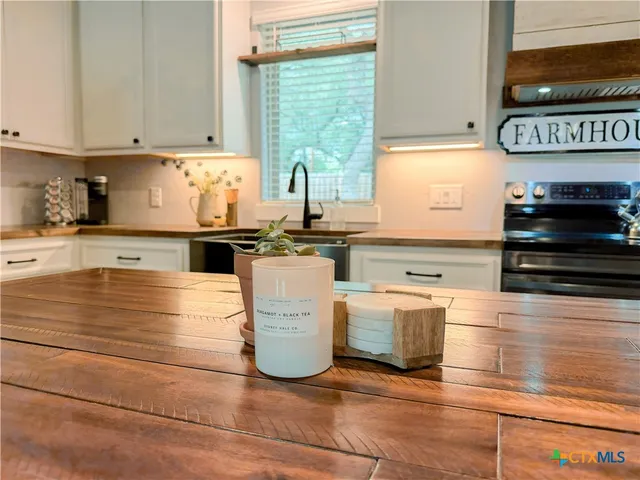 a kitchen with stainless steel appliances wooden cabinets and a stove top oven