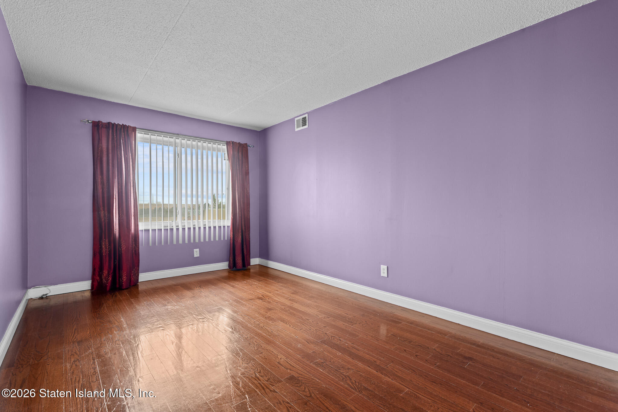 11 Windham Loop, Unit 5LL Staten Island, NY 10314 - Photo 12 of 19 an empty room with wooden floor and windows