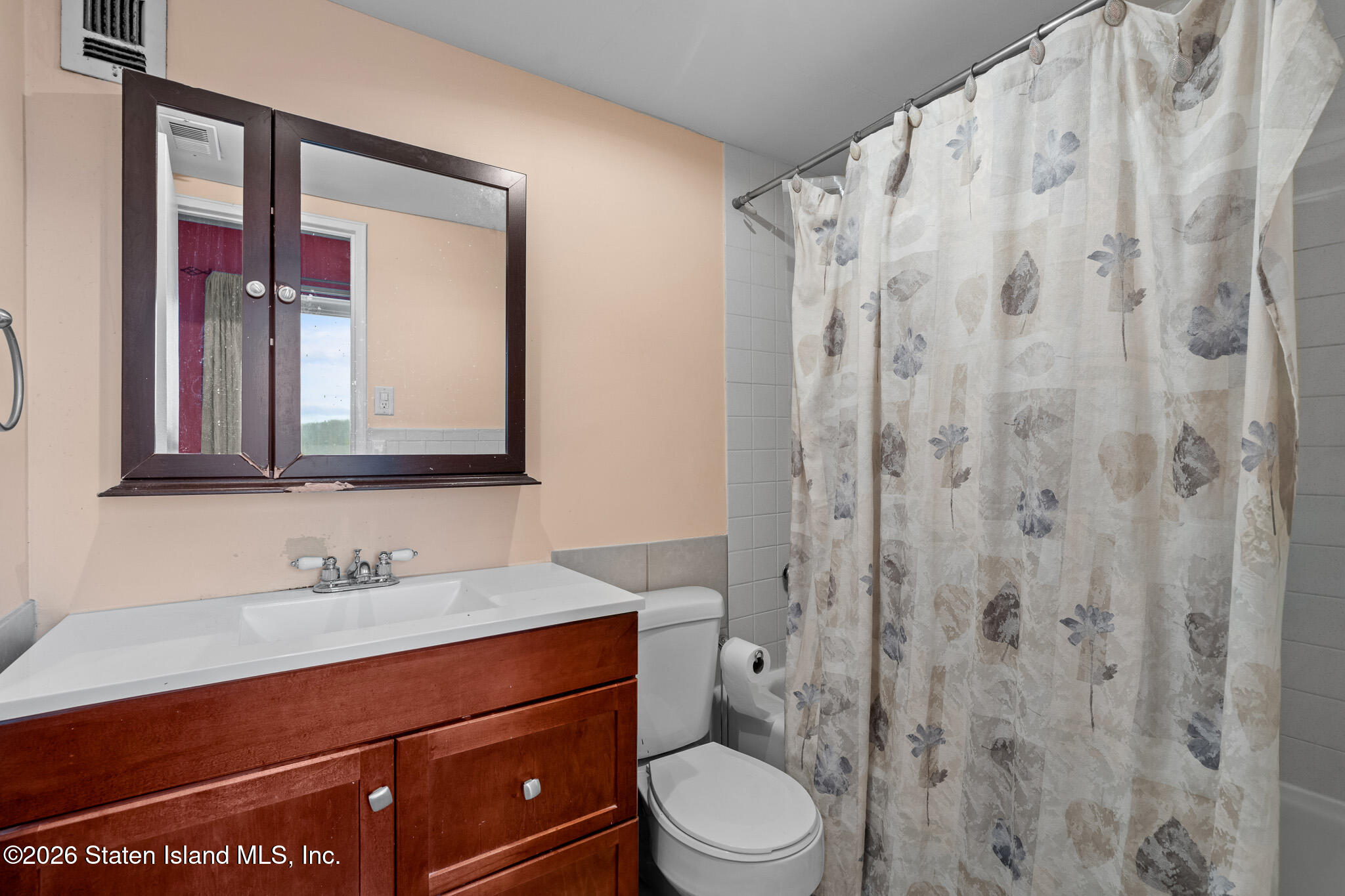 11 Windham Loop, Unit 5LL Staten Island, NY 10314 - Photo 17 of 19 a bathroom with a toilet a sink a mirror a vanity and shower