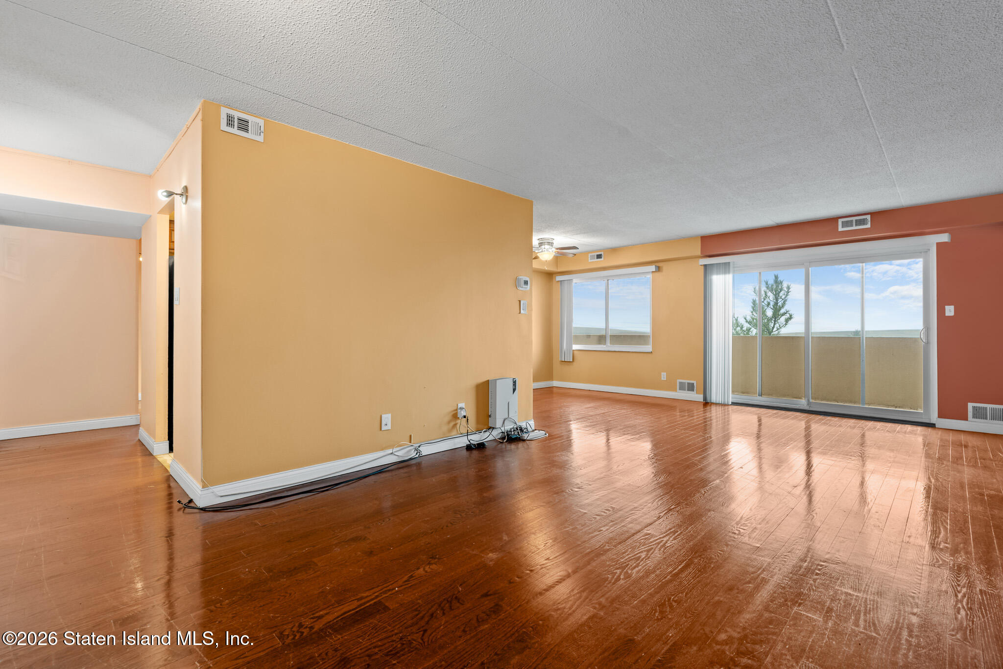 11 Windham Loop, Unit 5LL Staten Island, NY 10314 - Photo 5 of 19 an empty room with wooden floor and windows