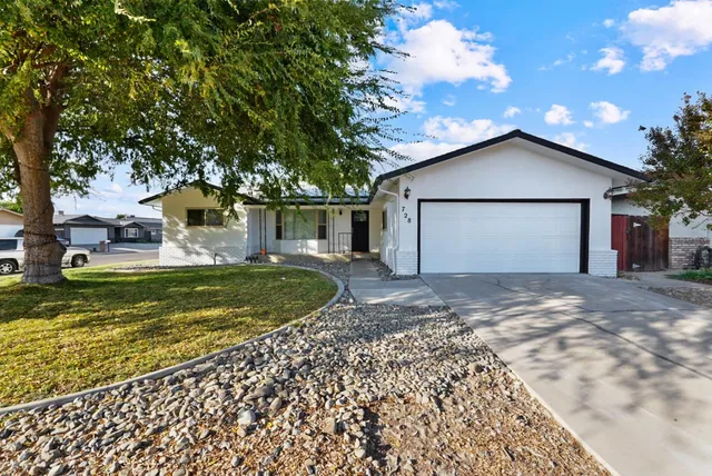 a view of a house with a yard patio and fire pit
